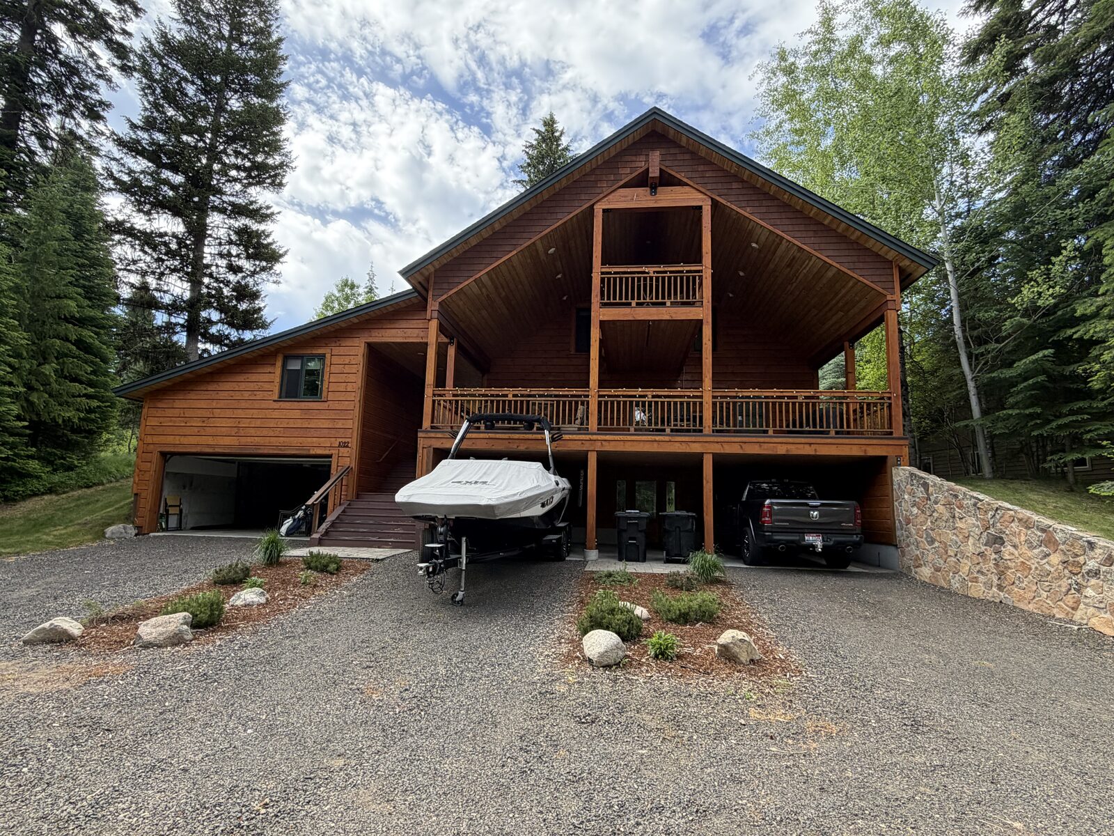 The Cedar Mountain Cabin — a two-story cedar cabin with a covered deck, nestled among the pines